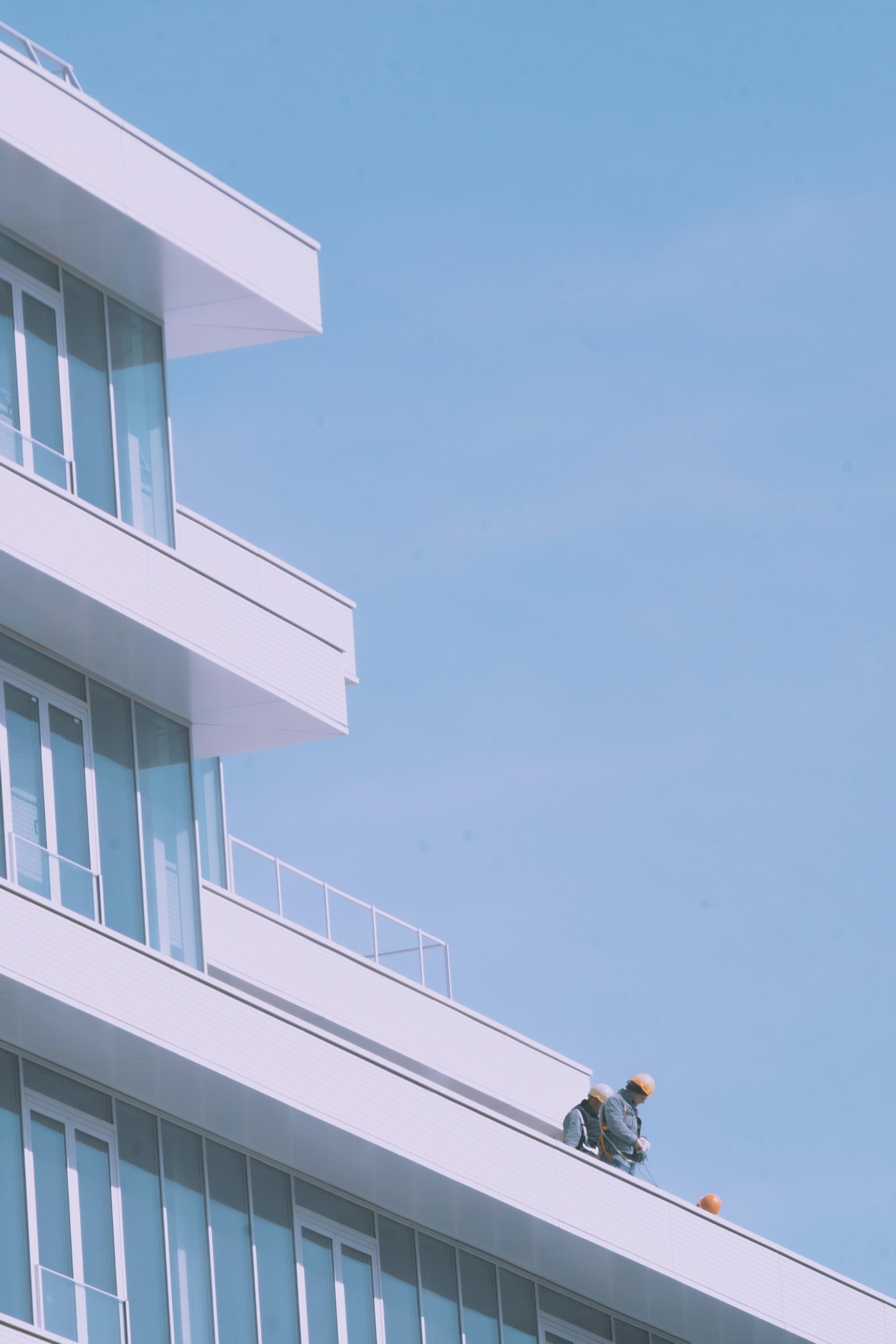 Roofing professionals working on a modern commercial building